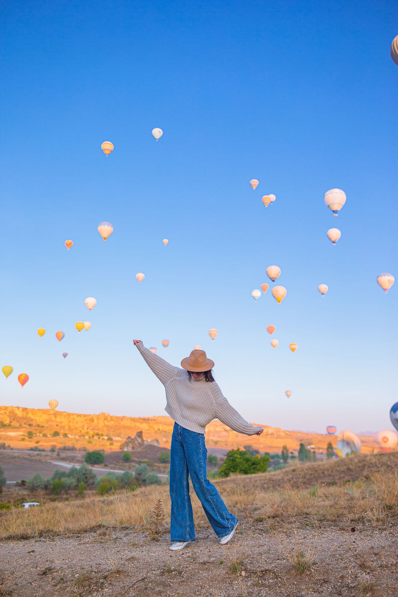 happy woman during sunrise watching hot air balloo 2021 12 09 20 23 59 utc